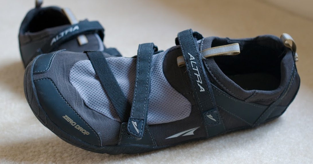 Ett par Altra Zero Drop minimalistiska löparskor med kardborreband. Dessa skor har en bred tåbox och ingen höjdskillnad mellan häl och tå, och följer principerna för barfotalöpning för en mer naturlig löpupplevelse med visst skydd.
